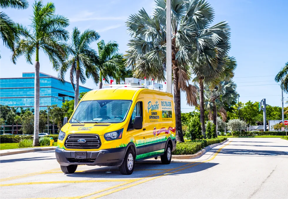 Pacific Lawn Sprinklers yellow service van parked near palm trees